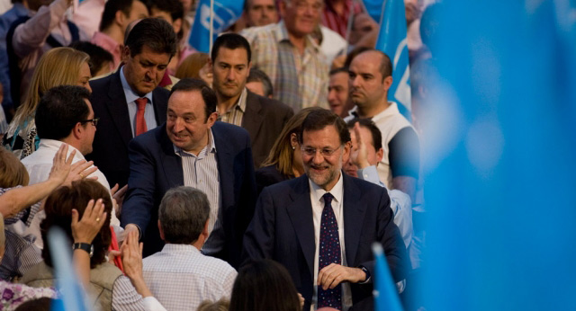 El presidente del PP, Mariano Rajoy, saluda a su llegada al acto junto a Pedro Sanz