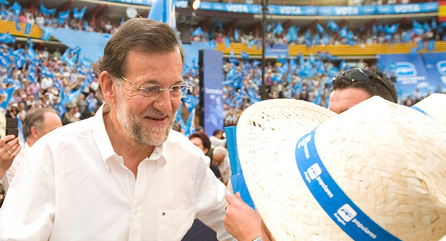 El presidente del PP, Mariano Rajoy, saluda a una señora