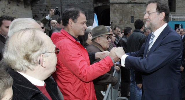 Mariano Rajoy saluda a unos hombres en la compostelana plaza del Obradoiro