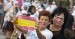 Asistentes al acto muestran orgullosas la bandera de España